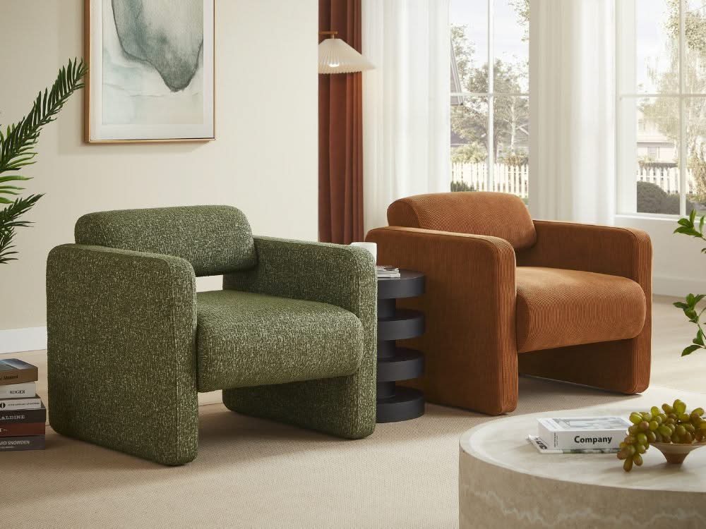 Two armchairs, one green and one brown, in a living room setting with a coffee table and decorative items.